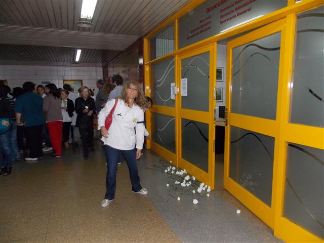 La licenciada Claudia Iturbe deja los claveles en la puerta del Directorio del Notti en señal de duelo